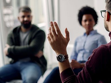 Eine Gruppe Menschen sitzen im Stuhlkreis in einer Gesprächsrunde