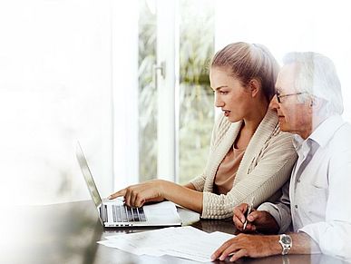 Tochter unterstützt ihren Vater am Laptop