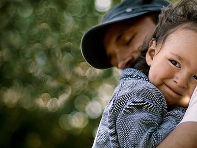 Kind auf dem Arm von Vater