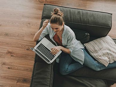 Frau sitzt auf Couch