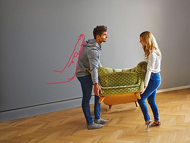 Mann und Frau heben ein Sofa