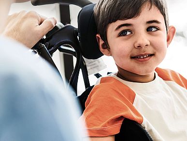 Kleiner Junge sitzt im Rollstuhl
