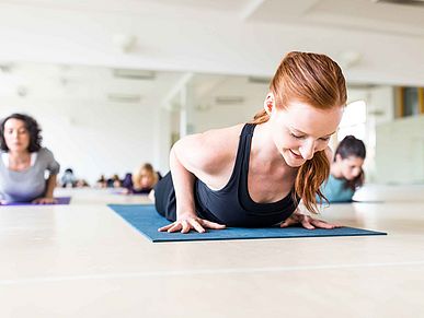 Frau liegt auf einer Matte während eines Trainingkurses