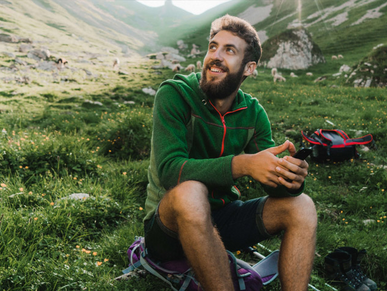 Mann macht eine Wanderpause auf einem schönen Wanderweg