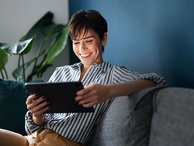 Frau mit Tablet auf einer Couch