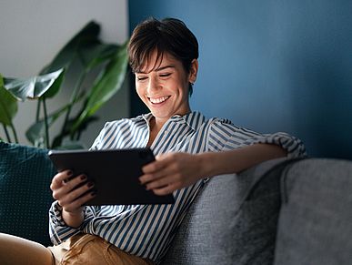 Frau mit Tablet auf einer Couch