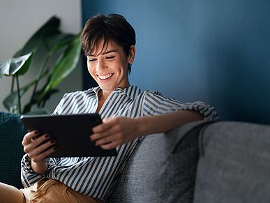 Frau mit Tablet auf einer Couch