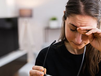Eine Frau hält sich den Kopf vor Kopfschmerzen