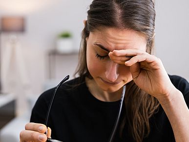 Eine Frau hält sich den Kopf