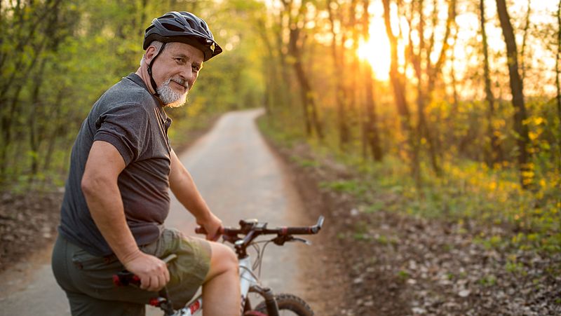 Mann mittleren Alters fährt im Wald Fahrrad 